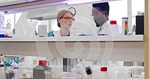 Diverse young scientists holding test tubes with sample developing vaccine in laboratory