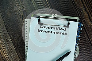 Diversified Investments write on a paperwork isolated on wooden table photo