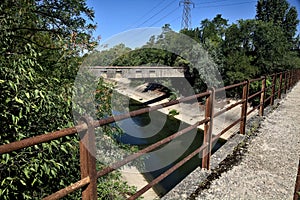 Diversionary channel bordered by trees seen from a bridge on a summer day photo
