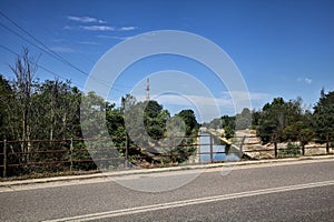 Diversionary channel bordered by trees seen from a bridge on a summer day photo