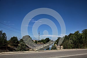 Diversionary channel bordered by trees seen from a bridge on a summer day photo