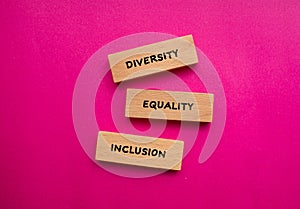 Diversity, equality, inclusion words written on wooden blocks with pink background