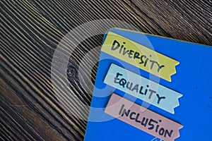 Diversity, Equality, Inclusion write on sticky notes isolated on Wooden Table