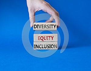 Diversity Equity Inclusion symbol. Concept words Diversity Equity Inclusion on wooden blocks. Beautiful blue background.