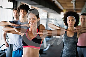 Diversity group of people training in a gym. Trainer and sportive persons exercising