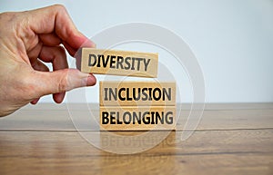 Diversity, inclusion and belonging symbol. Wooden blocks with words `diversity, inclusion, belonging` on beautiful white