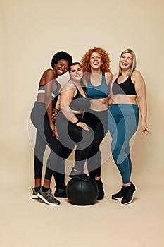 Diversity Models. Different Race And Size Women. Group Of Multicultural Friends In Sportswear With Black Fitness Ball.