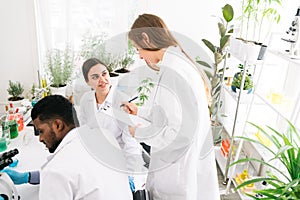 The diversity of scientists reports experimentation results to their colleagues in the research laboratory. Group of chemistry