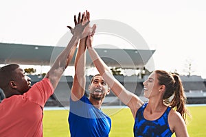 Diversity, team and high five on stadium track for running, exercise or training together in athletics. Group touching