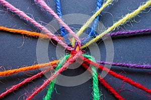 Diversity, teamwork and unity concept. Close-up of connected colored threads.