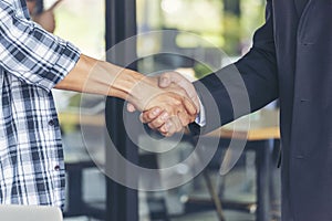 Diversity two business partners shaking hands together with business contract mergers and acquisitions. Close up honest hands