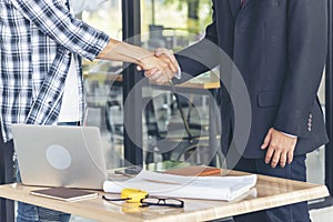 Diversity two business partners shaking hands together with business contract mergers and acquisitions. Close up honest hands