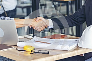 Diversity two business partners shaking hands together with business contract mergers and acquisitions. Close up honest hands