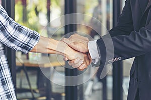 Diversity two business partners shaking hands together with business contract mergers and acquisitions. Close up honest hands