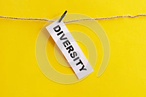 Diversity word written on white paper on yellow background. Equality and diversity concept