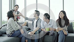 Diversity of young people group team holding coffee cups and discussing something with smile while sitting on the couch at office.