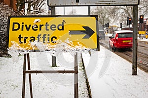 Diverted traffic sign under winter snow fall in england uk