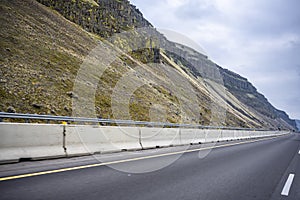 Divided highway road with car hauler big rig semi truck and rocky mountains in Columbia Gorge national recreation area