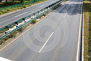 Divided urban thoroughfare with guardrails and fencing