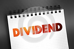 Dividend - distribution of profits by a corporation to its shareholders, text on notepad, concept background