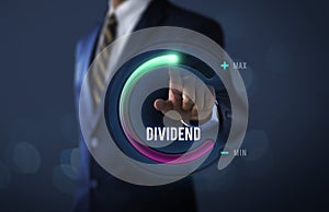 Dividend growth or increase dividend concept. Businessman is pulling up circle progress bar with the word DIVIDEND on dark tone