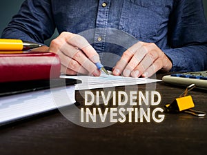 Dividend investing phrase and manager works with papers.