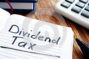 Dividend tax concept. Note pad and calculator