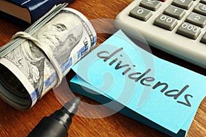 Dividends concept. Stack of dollars and calculator photo