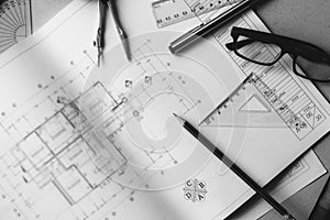 Divider, pencil, pen, ruler, glasses and smartphone and blueprint on table top.Table top view of Engineers table at office