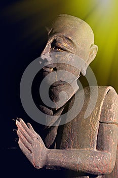 Divine light of spiritual awakening. Buddhist monk in serene prayer pose. photo