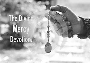 The Divine Mercy Devotion concept with a prayer hand holding The Divine Mercy rosary beads with the holy heart of Jesus Christ,