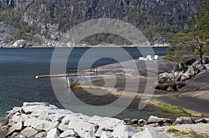Diving board and stone lounge chairs on natural bathing platform on a sunny day, Eidfjord, Hordaland photo