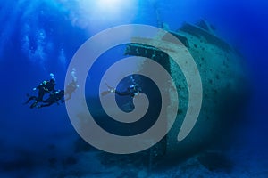 A diving instructor leads a group of divers through a big shipwreck