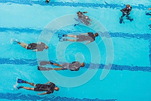 Diving instructor and students. Instructor teaches students to dive