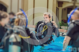Diving instructor and students. Instructor teaches students to dive
