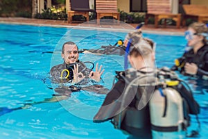 Diving instructor and students. Instructor teaches students to dive