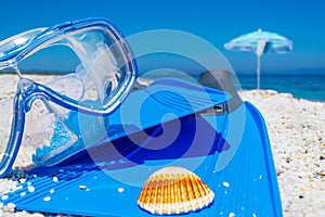 Diving mask and flippers on white sand