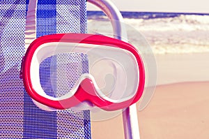 Diving mask hanging in a deckchair with a retro filter effect