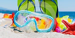 Diving mask and sandals on the beach