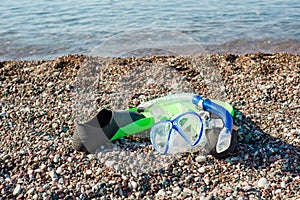 Diving mask, snorkel and fins on a beach