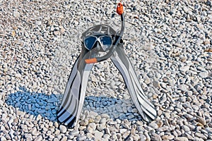 Diving mask, a snorkel and swimfins on the stonig beach of Adriatic sea. Snorkel equipment. Activity sport leisure