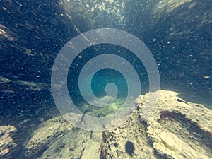 Diving through natural underwater tunnel at sea.