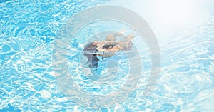 Diving in pool. Happy little girl spending time in pool