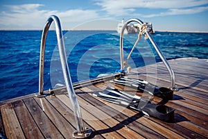 Diving with scuba gear and flippers in sea, snorkeling tour on boat yacht. Bright photo with sun extreme rest