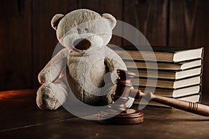 Divorce and alimony concept. Wooden gavel and teddy bear as symbol of child on a desk