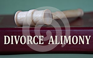 DIVORCE ALIMONY - words on a burgundy folder on the background of a judge\'s gavel photo