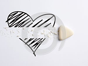Divorce, breakup, ending love in a romantic relationship concept. White eraser erases the heart icon