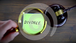 Divorce concept. Man`s hand holding magnifying glass