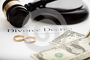 Divorce decree, gavel and wedding rings.