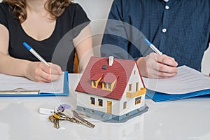 Divorce and dividing a property concept. Man and woman are signing divorce agreement